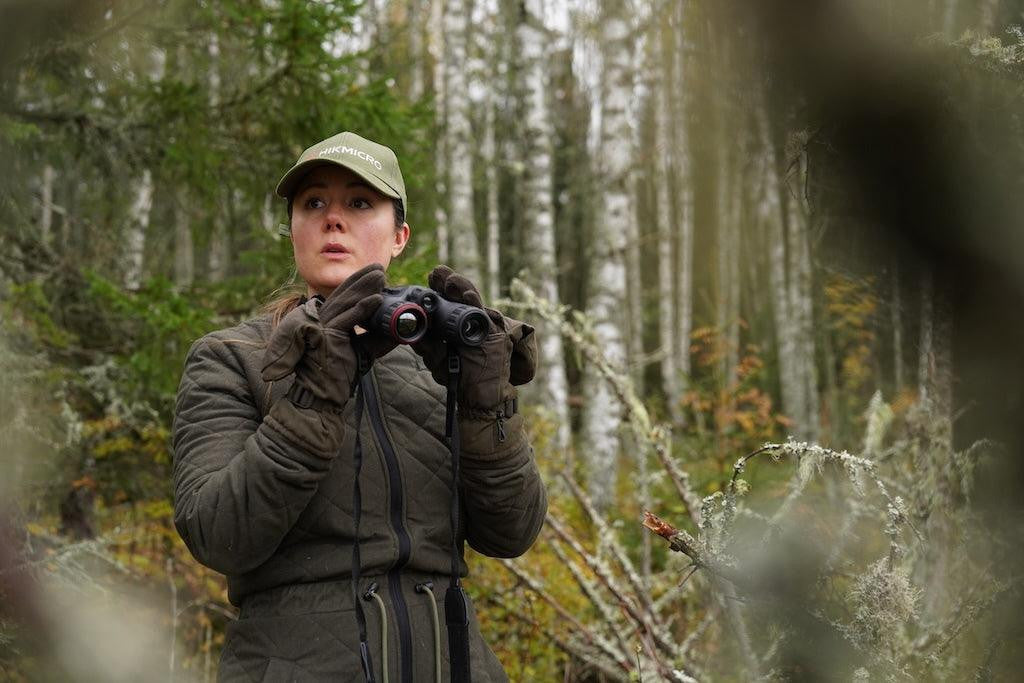 Person in a forest using binoculars